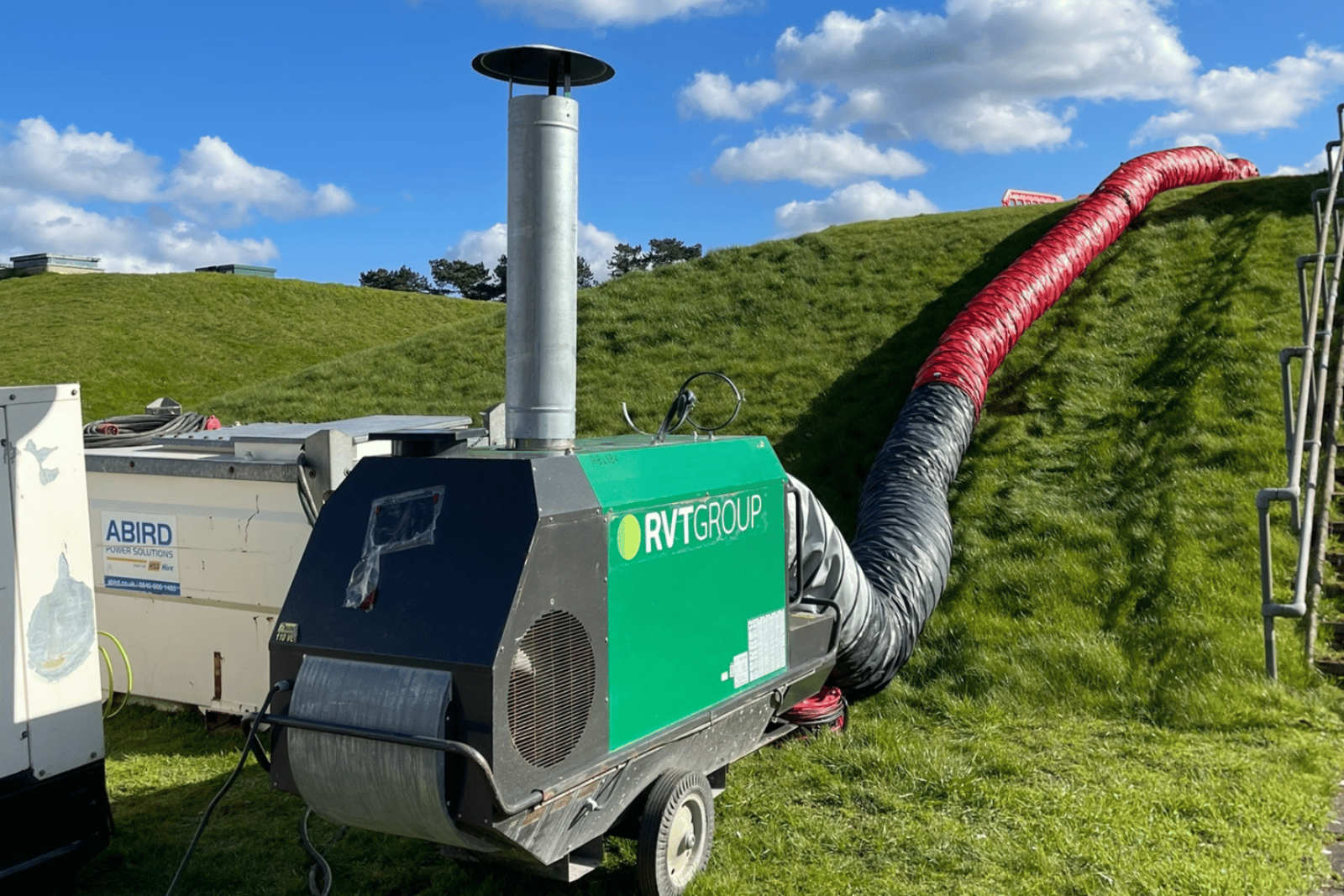 Climex Indirect Oil-Fired Heater at the bottom of a hill nearby to a reservoir with ducting going up the hill supplying heat to the project