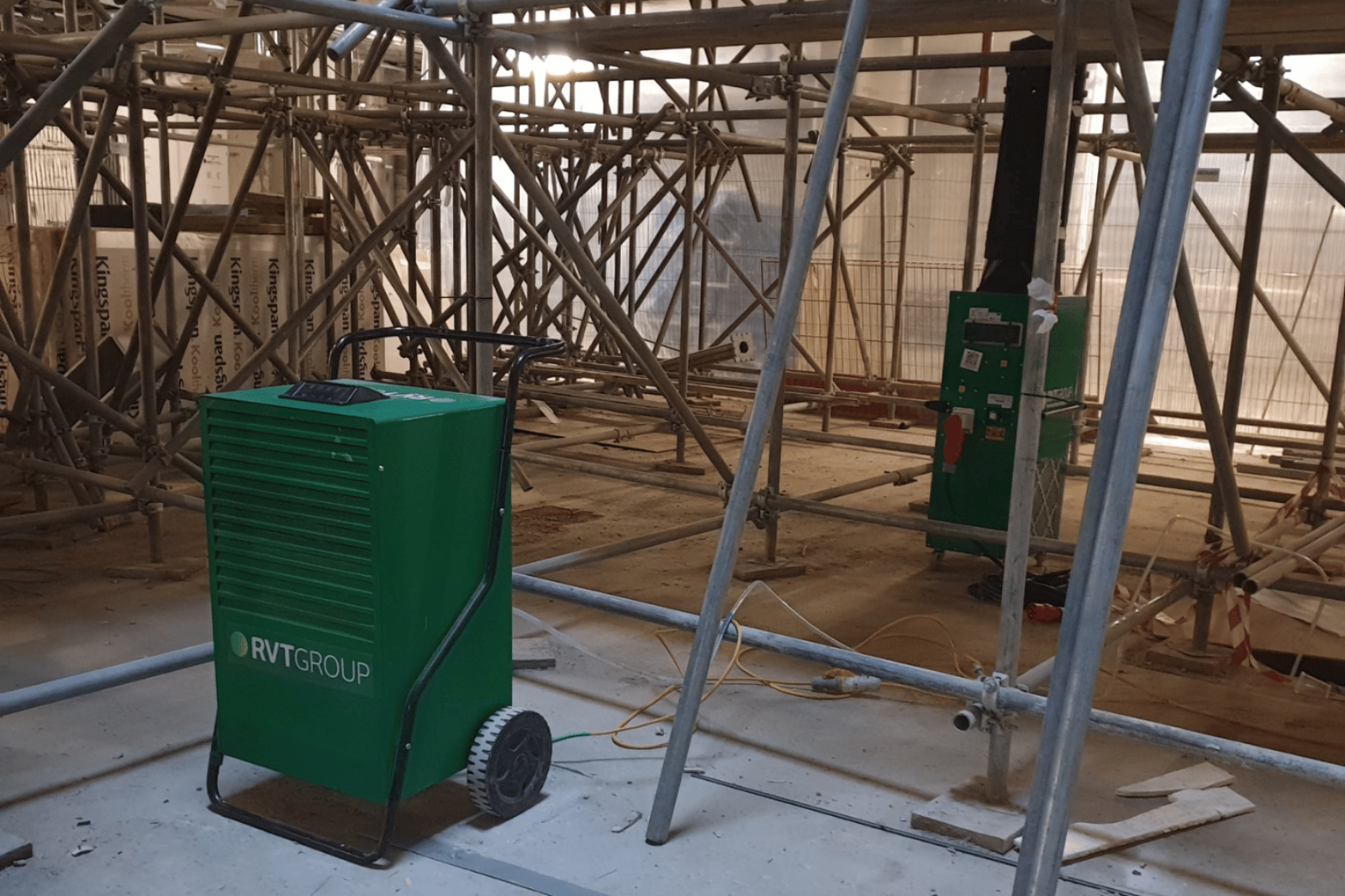 Climex Dehumidifier 96 Litre and 18FD electric heater supplying heat to a live construction project, stood amongst erected scaffolding
