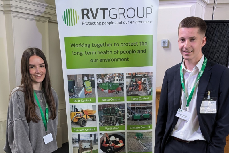 Work experience placements Suzy (left) and Jamie (right) with an RVT Group banner between them