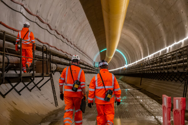 Infrastructure workers in PPE walking through HS2 tunnel
