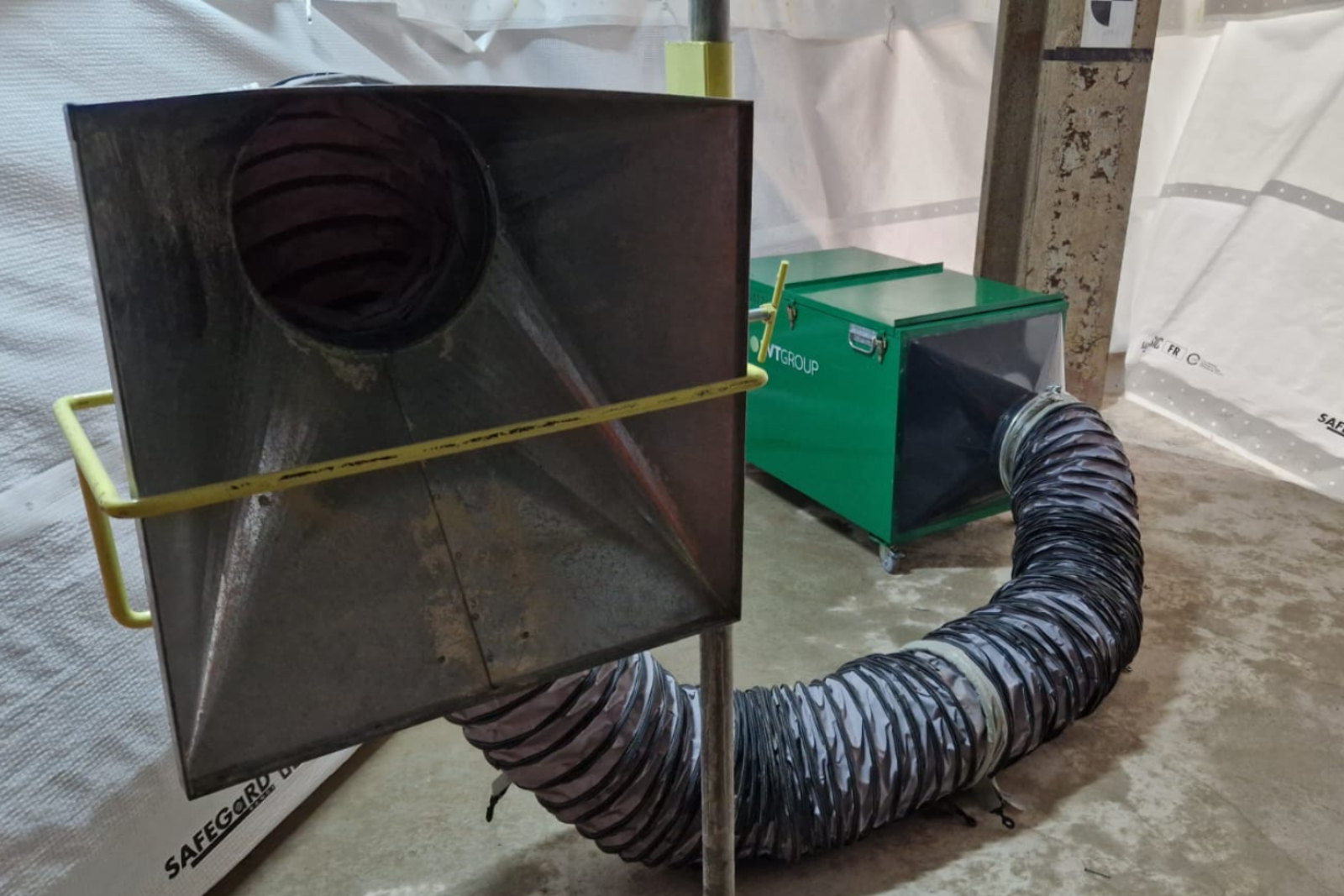 Close up of a metal capture hood with a metal LEV, dust and fume extraction unit in the background