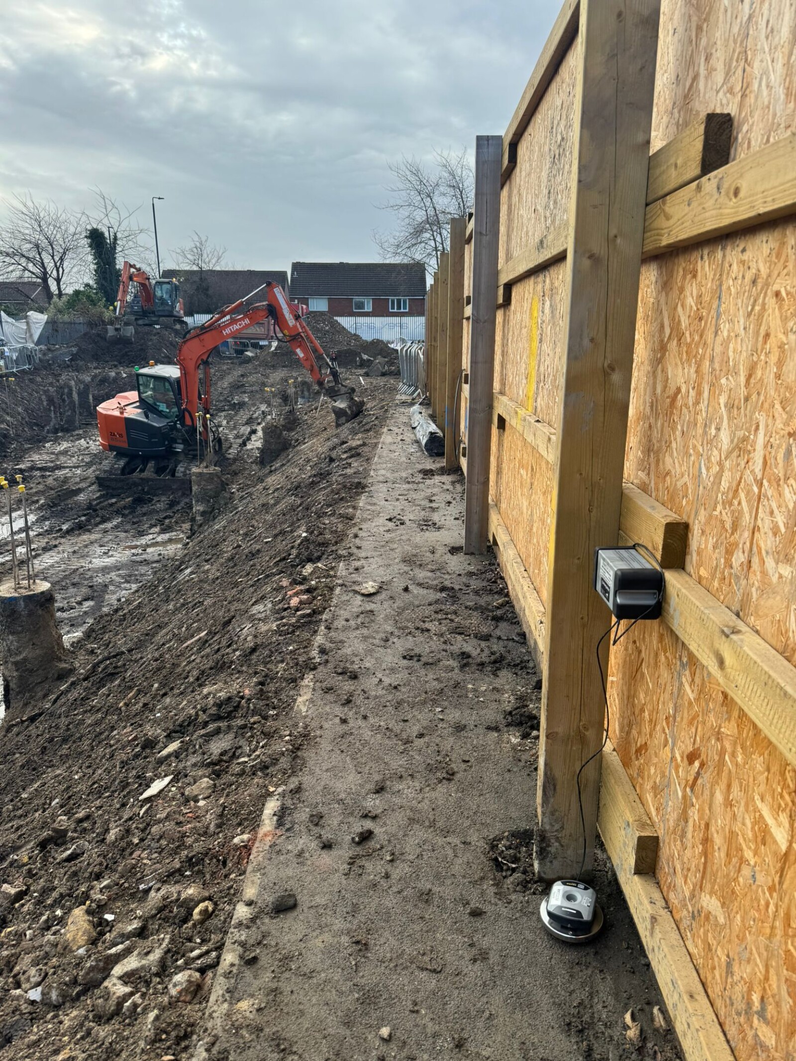 MONITEX OD-AA Vibration Monitor on a fence panel with excavation taking place in the background