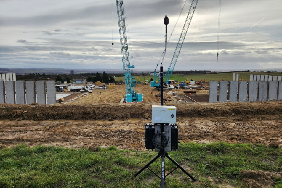 Noise monitor in the foreground and construction activity in the background