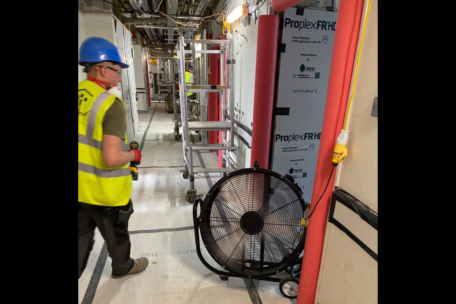 VENTEX® Floor Fan 800M providing cooling for two workmen whilst installing electrics on a project