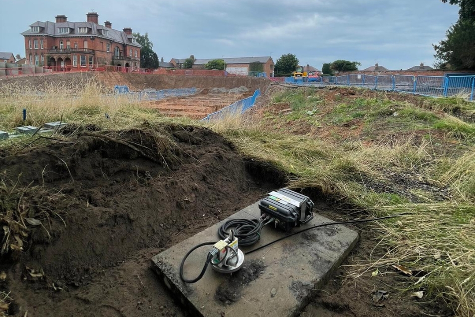 Vibration monitor in the foreground and construction work in the background