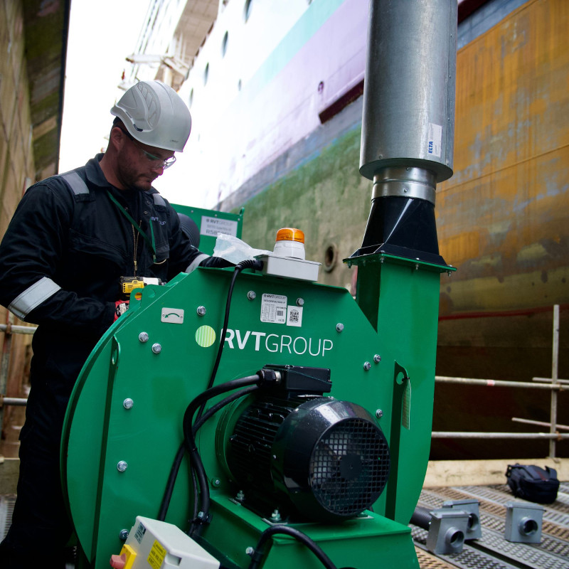 Engineer on temporary stand within a dockyard setting up equipment