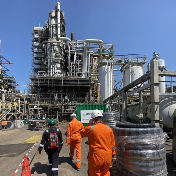 Oil refinery with RVT Group consultants walking to it