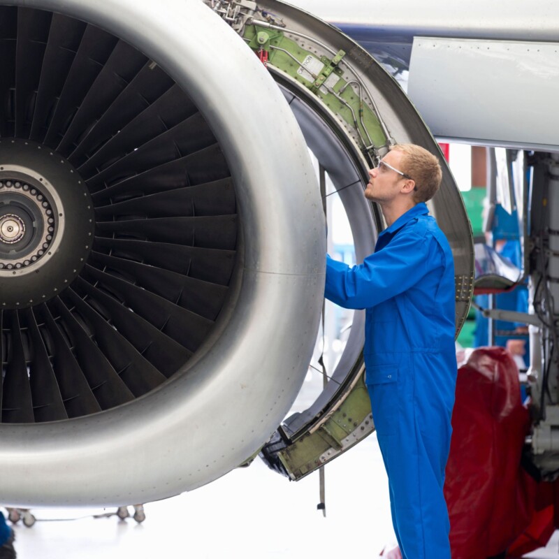 aviation engineer looking into airplane